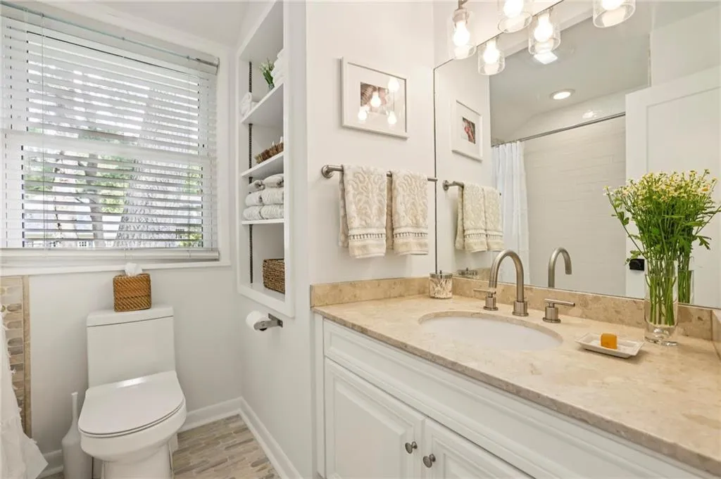 Full bathroom featuring vanity, light wood-style flooring, and a shower with shower curtain