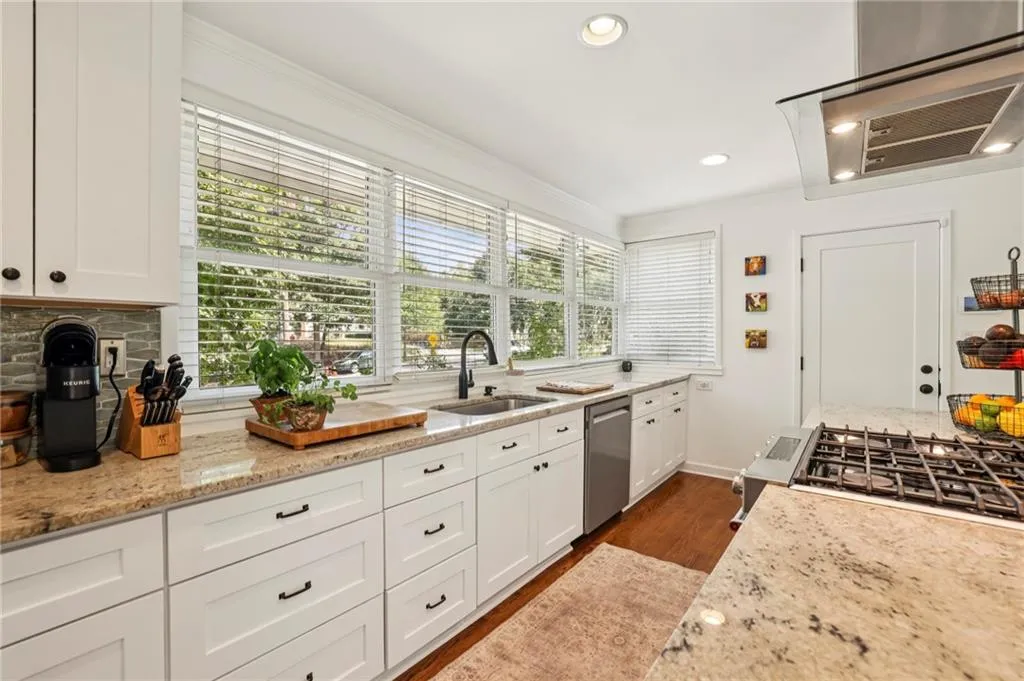 Kitchen featuring light stone counters, extractor fan, dark wood finished floors, recessed lighting, and white cabinets