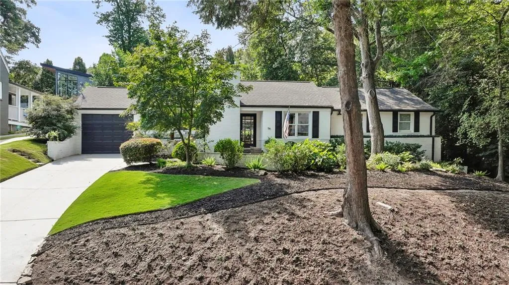 View of front of property with concrete driveway, an attached garage, and roof with shingles