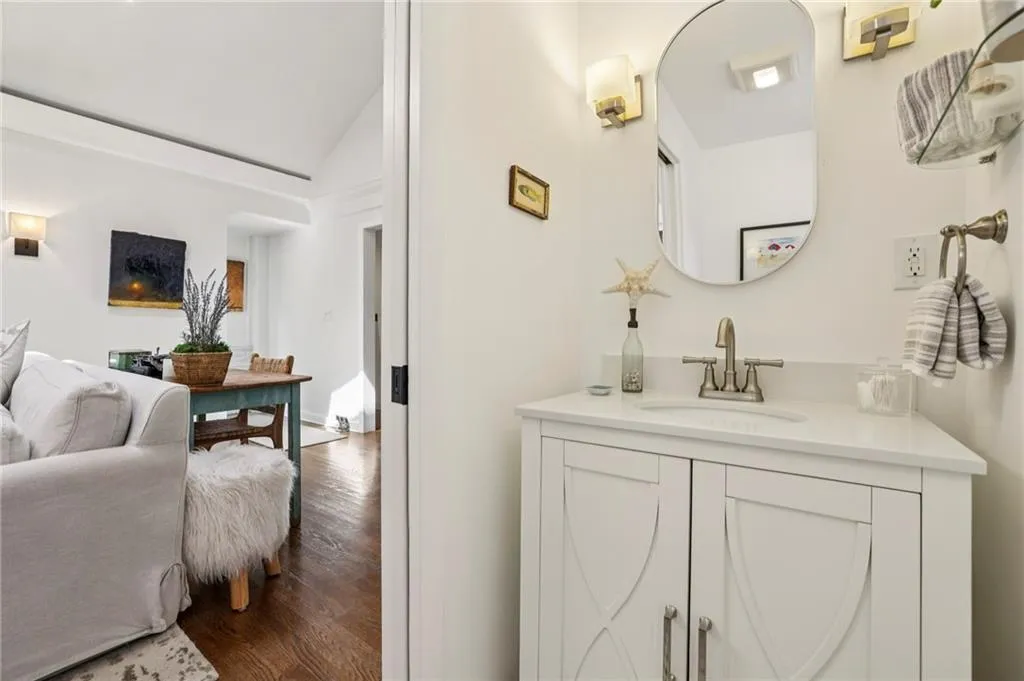Bathroom with vanity, dark wood-style flooring, and lofted ceiling