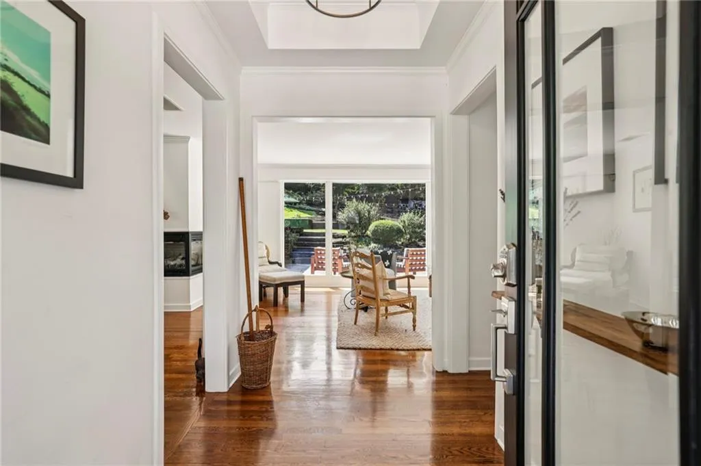 Entryway featuring wood finished floors, a tray ceiling, and crown molding