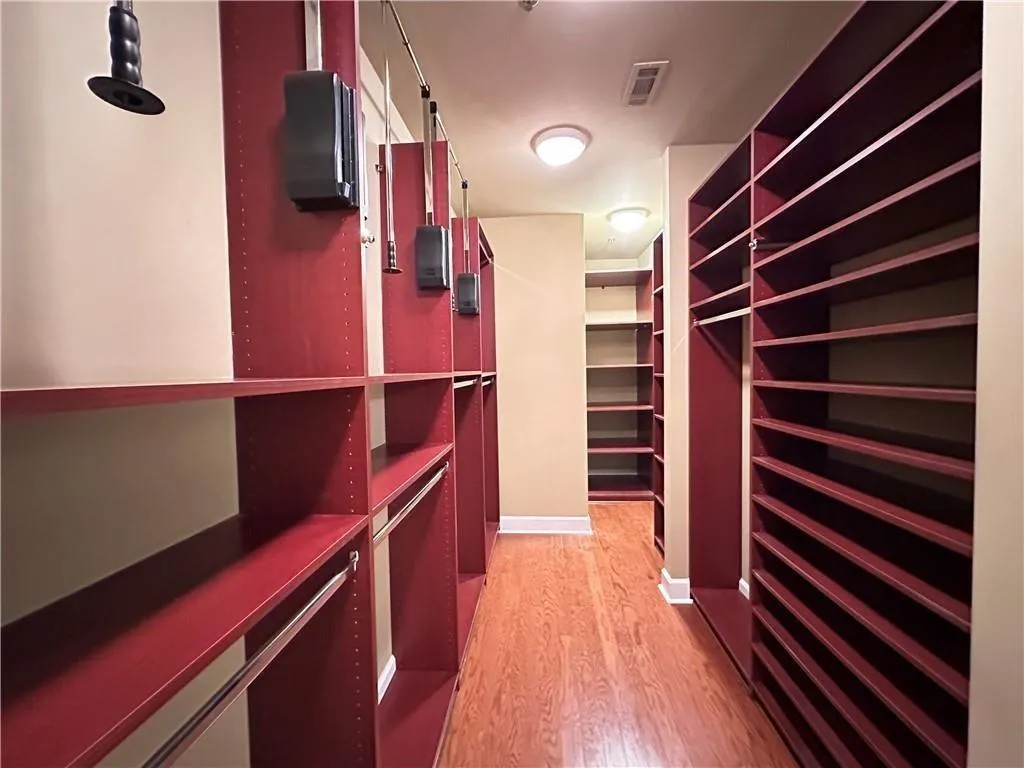 Walk in closet with light wood-type flooring
