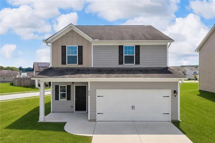 Two-story residence featuring a covered front porch, an attached two-car garage, and a concrete driveway