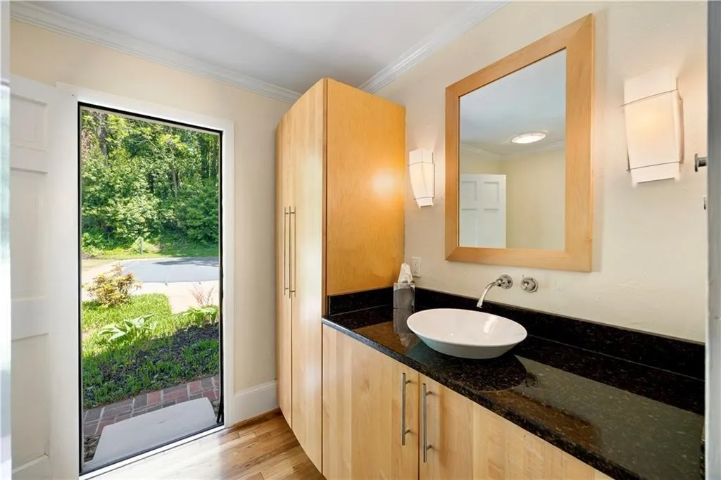 Bathroom with baseboards, wood finished floors, crown molding, and vanity