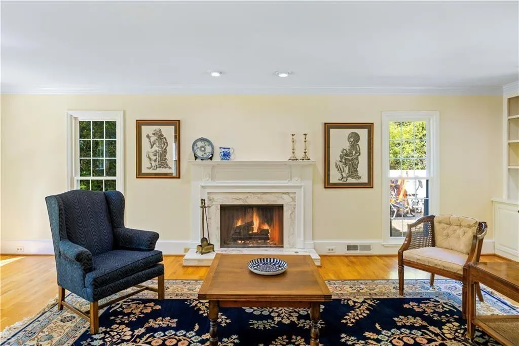 Sitting room with wood finished floors, visible vents, ornamental molding, and plenty of natural light