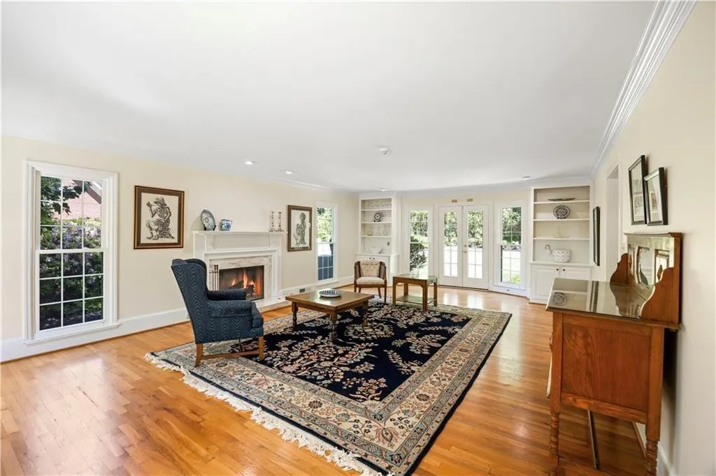 Living room with built in shelves, a wealth of natural light, and ornamental molding