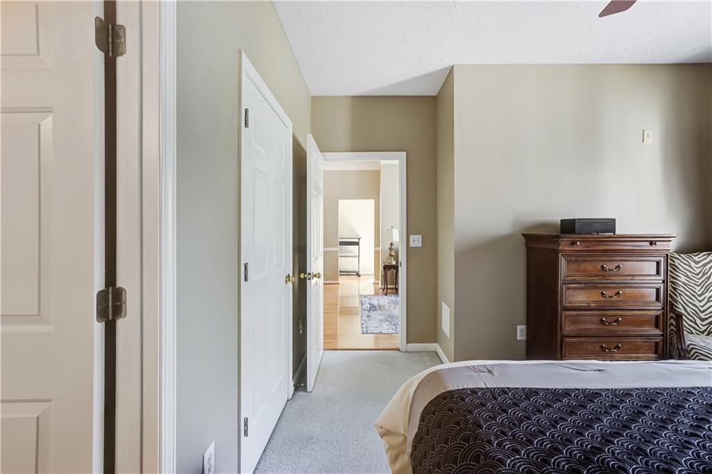 Carpeted bedroom featuring ceiling fan