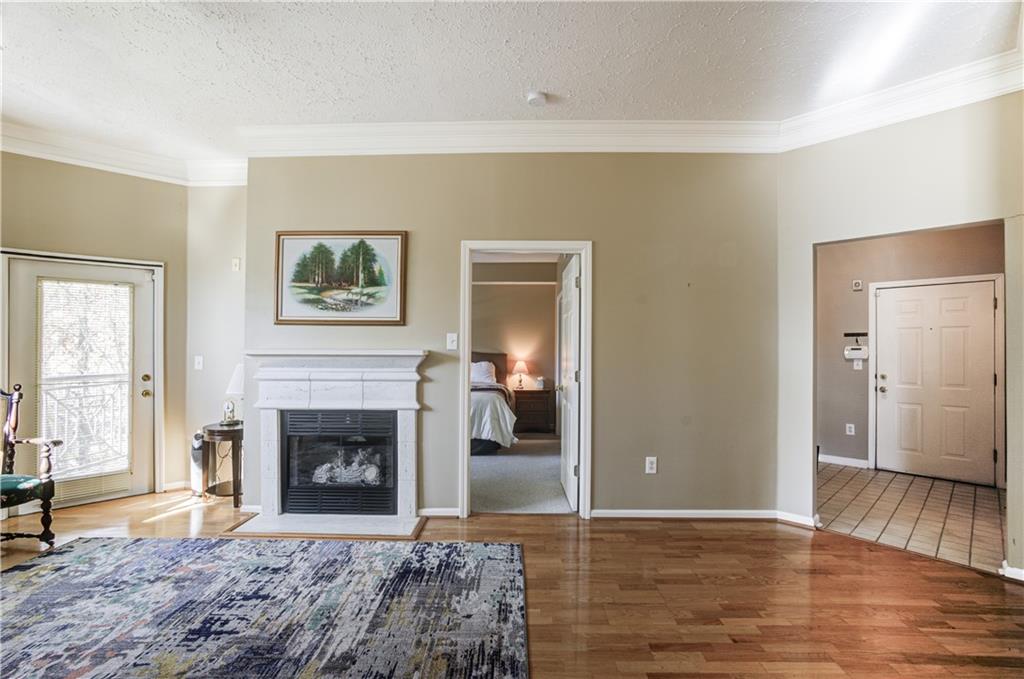 Living room featuring crown molding, a textured ceiling, and hardwood / wood-style floors