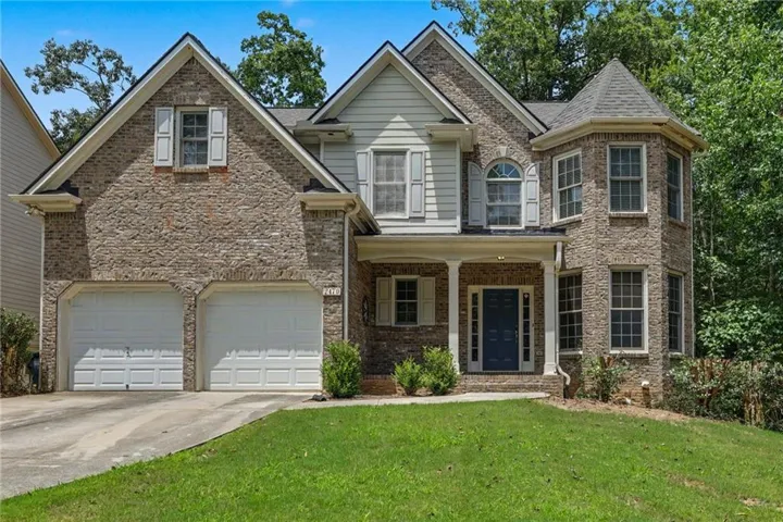 Traditional brick and siding exterior featuring a two-car garage