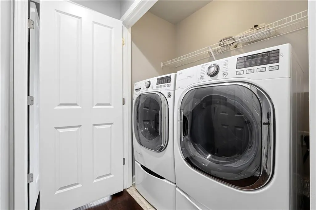 Laundry area featuring independent washer and dryer and dark wood-style flooring