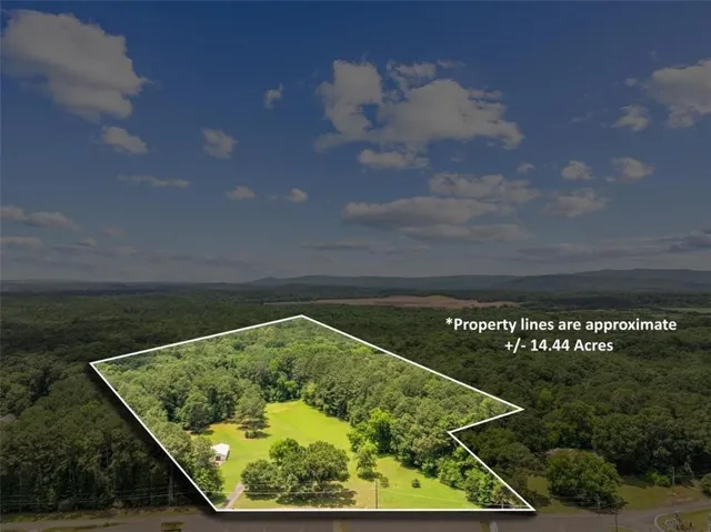 Expansive land parcel featuring open clearings and mature tree coverage