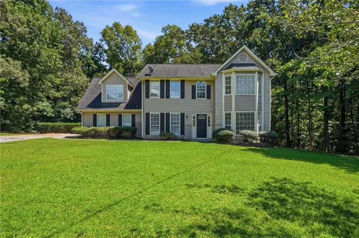 Two-story residence with a prominent bay window, dormer windows, and a classic front door