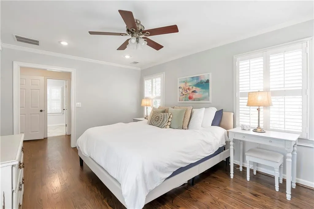 Bedroom featuring ceiling fan, crown molding, and dark wood-type flooring