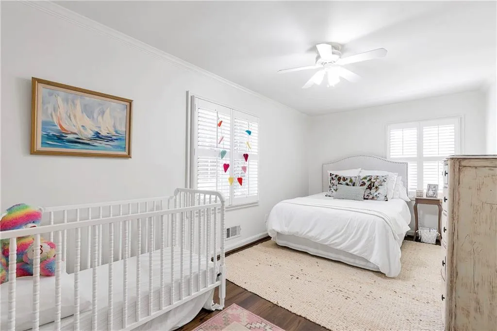 Bedroom with ceiling fan, dark hardwood / wood-style floors, and crown molding