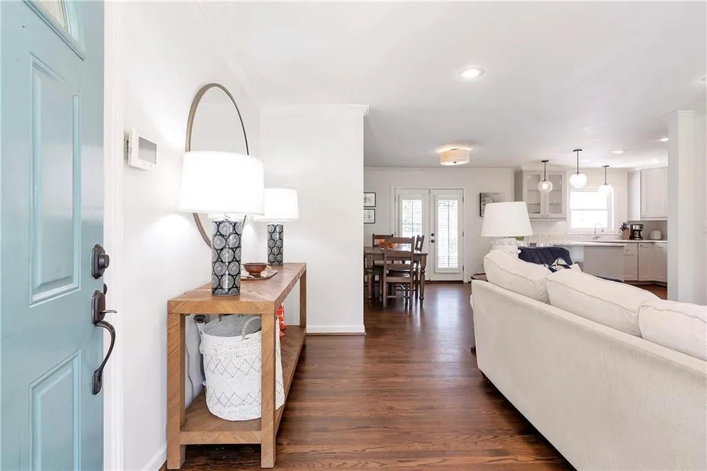 Living room with ornamental molding, dark hardwood / wood-style flooring, and sink