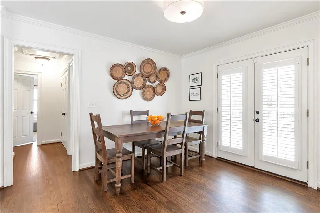 Dining area with french doors, dark hardwood / wood-style flooring, ornamental molding, and a wealth of natural light