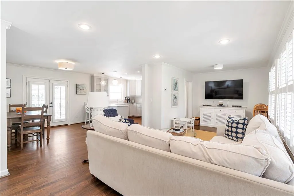 Living room with french doors, dark wood-type flooring, and ornamental molding