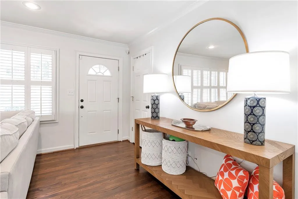 Entrance foyer with dark hardwood / wood-style floors and crown molding