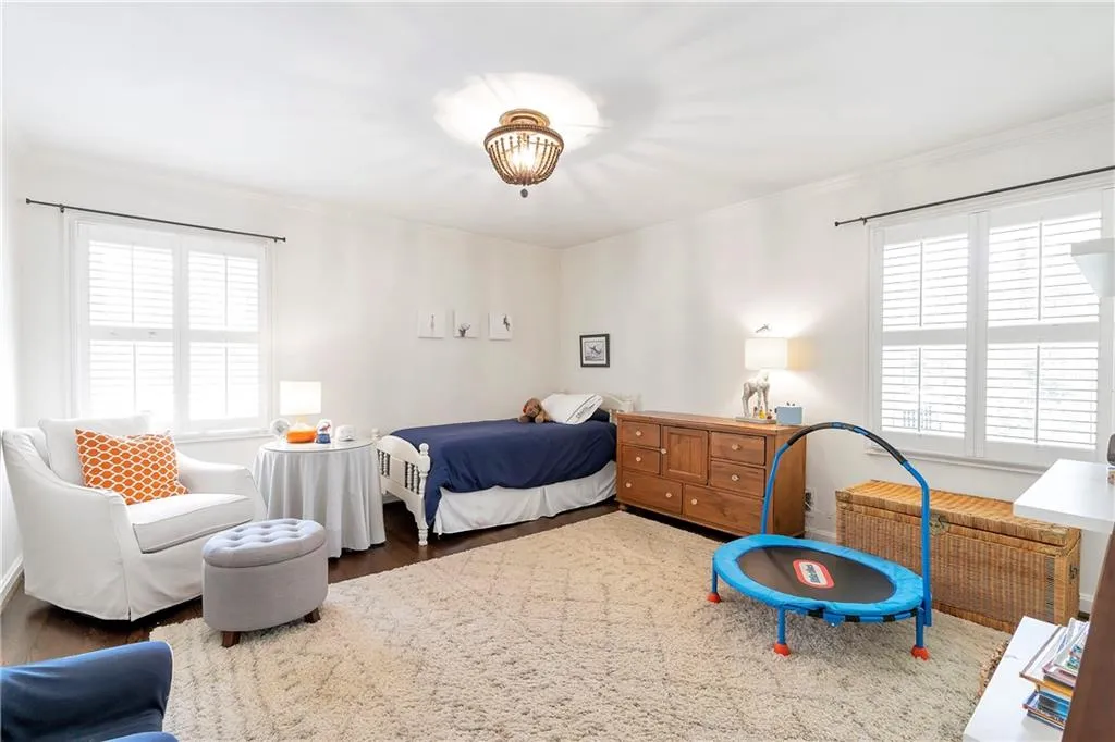 Bedroom featuring multiple windows, dark hardwood / wood-style flooring, and ornamental molding
