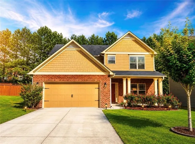 Brick and siding exterior featuring a two-car garage