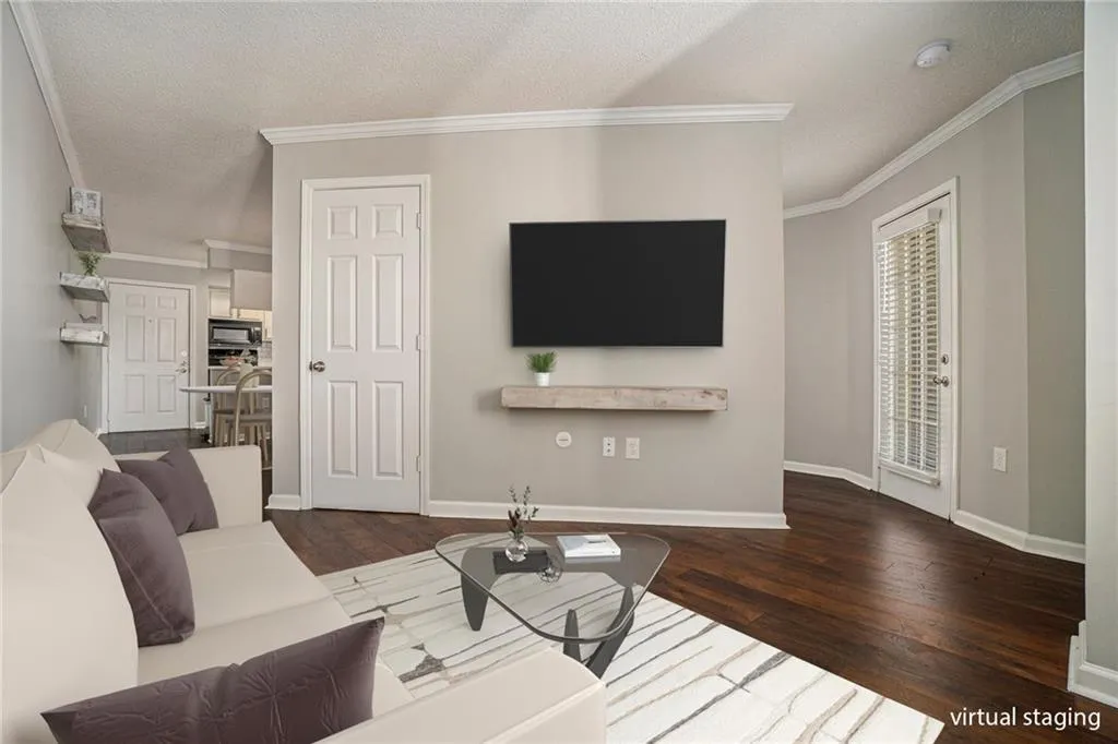 Living room featuring dark hardwood / wood-style flooring, crown molding, and a textured ceiling