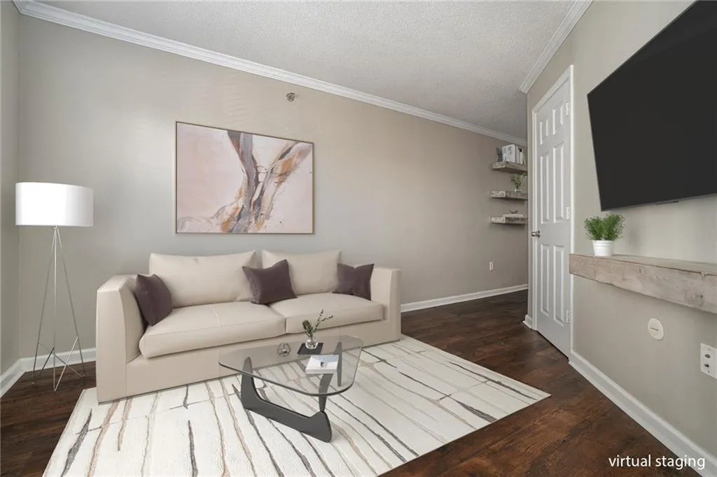 Living room featuring dark wood-type flooring, crown molding, and a textured ceiling