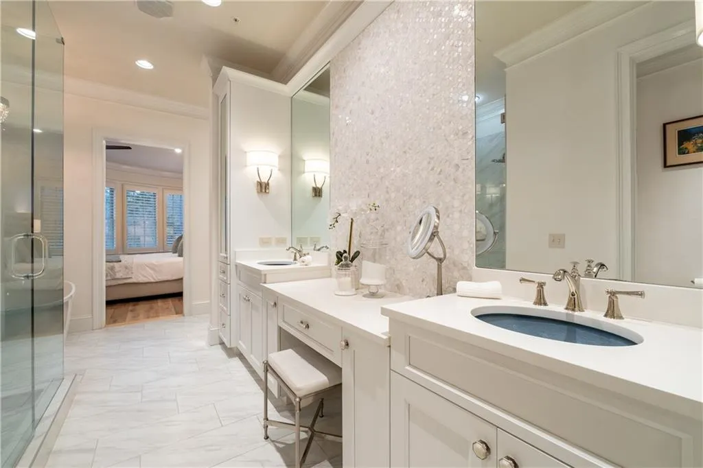 Bathroom with ornamental molding, vanity with extensive cabinet space, tile flooring, and dual sinks