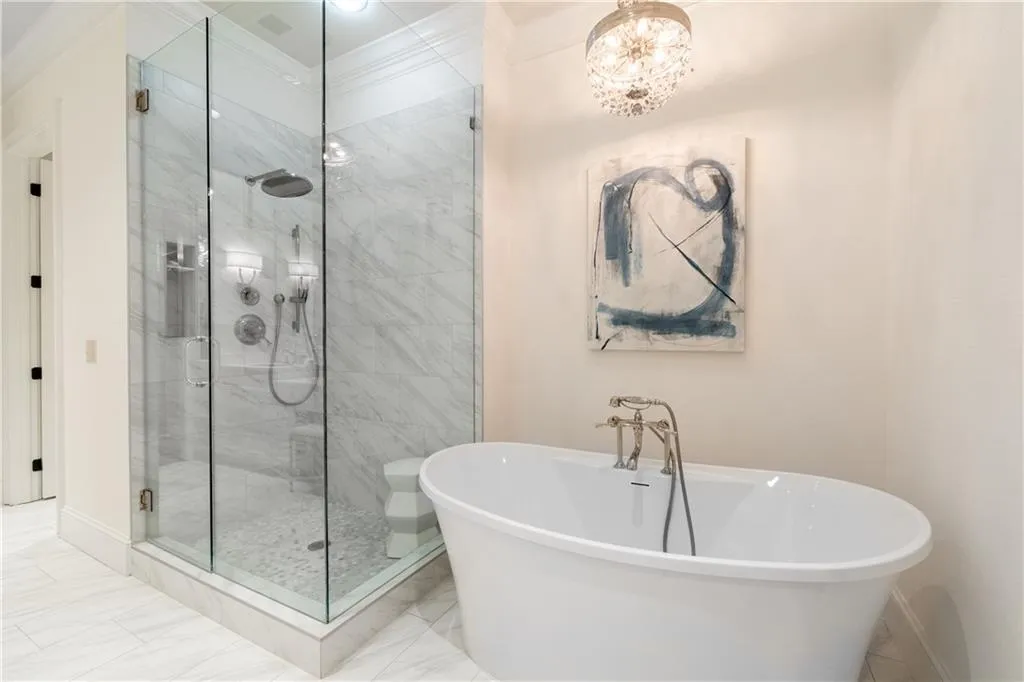 Bathroom featuring shower with separate bathtub, crown molding, tile floors, and an inviting chandelier