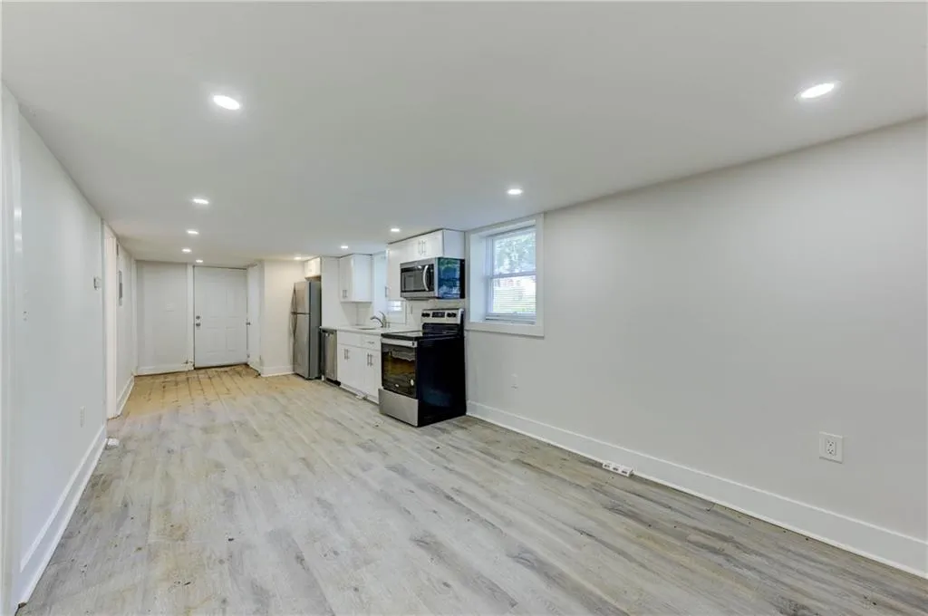 Kitchen with appliances with stainless steel finishes, white cabinets, recessed lighting, light wood-type flooring, and light countertops