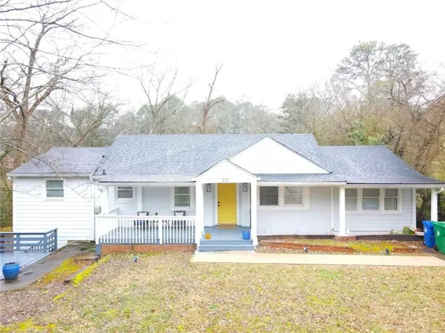 Bungalow featuring covered porch, a front yard, and roof with shingles