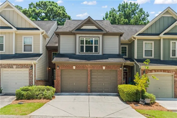 Brick and siding exterior featuring a two-car garage