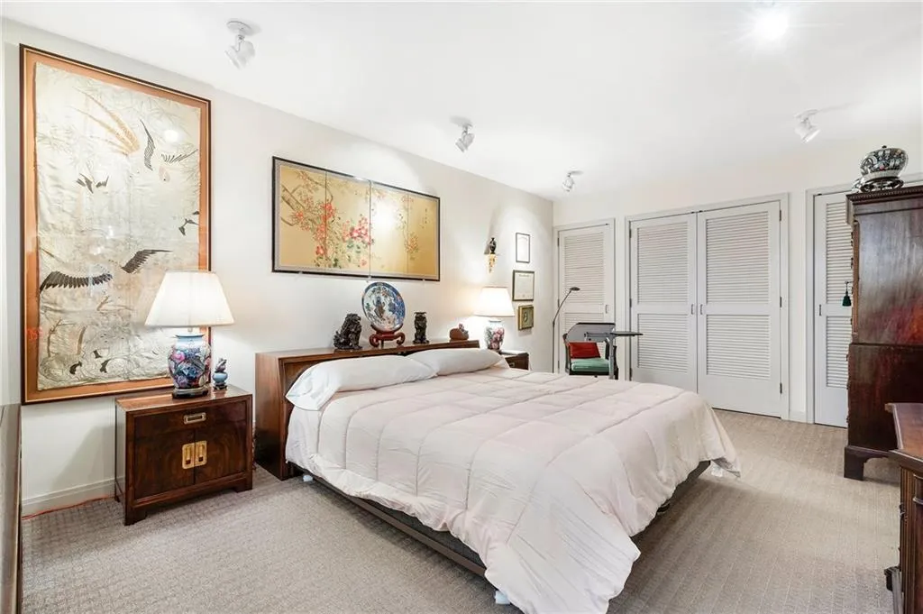 Bedroom with light carpet, baseboards, and two closets