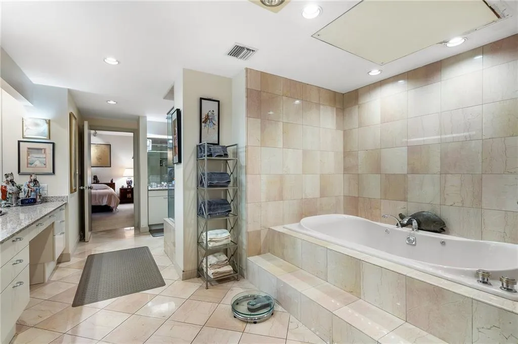 Bathroom with a garden tub, tile walls, visible vents, ensuite bathroom, and tile patterned floors