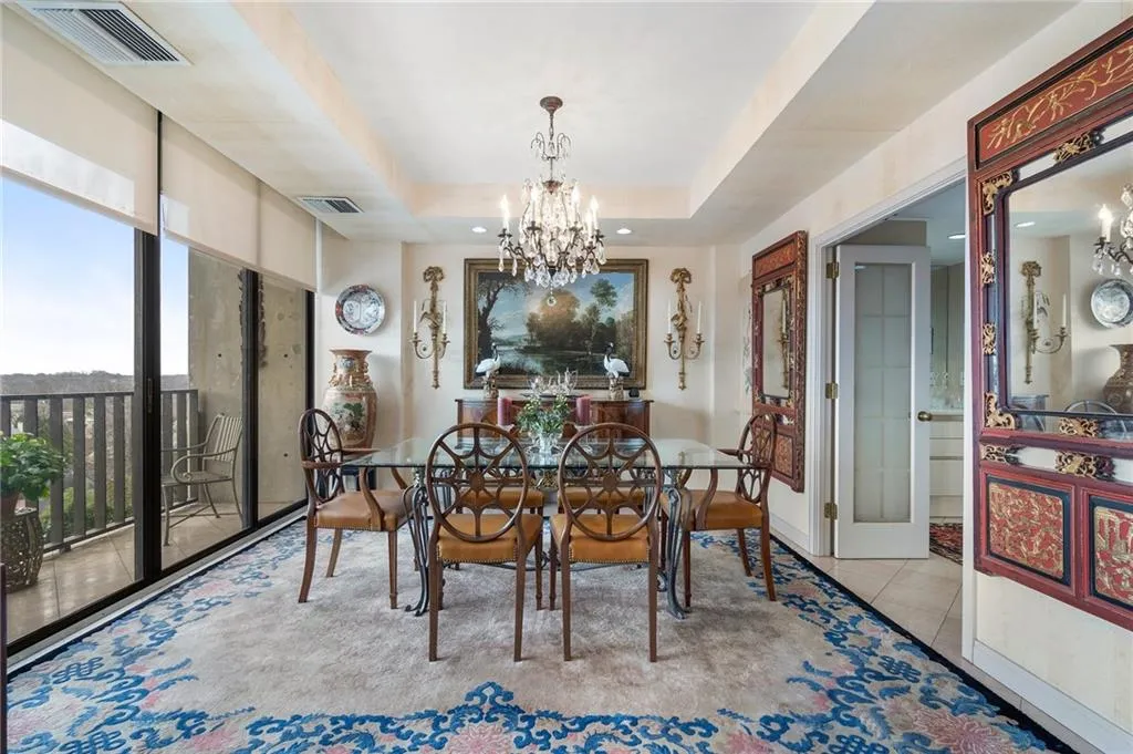 Tiled dining area featuring a raised ceiling, visible vents, and a notable chandelier