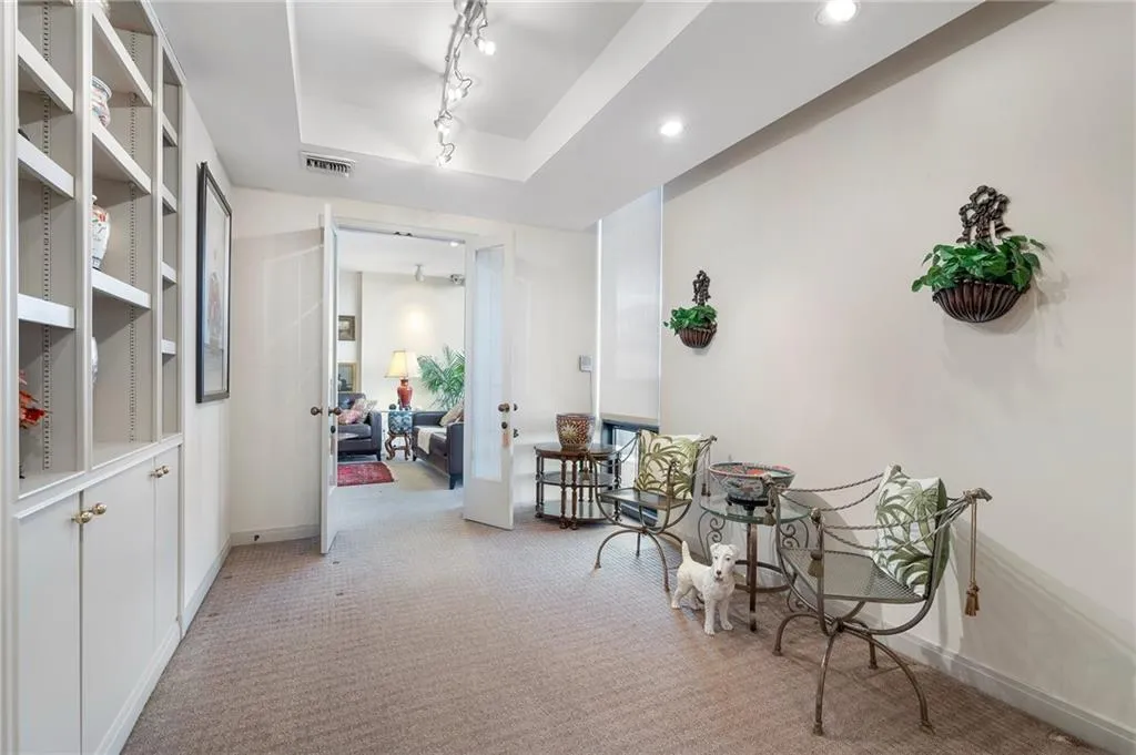 Hallway featuring recessed lighting, light carpet, visible vents, a tray ceiling, and track lighting
