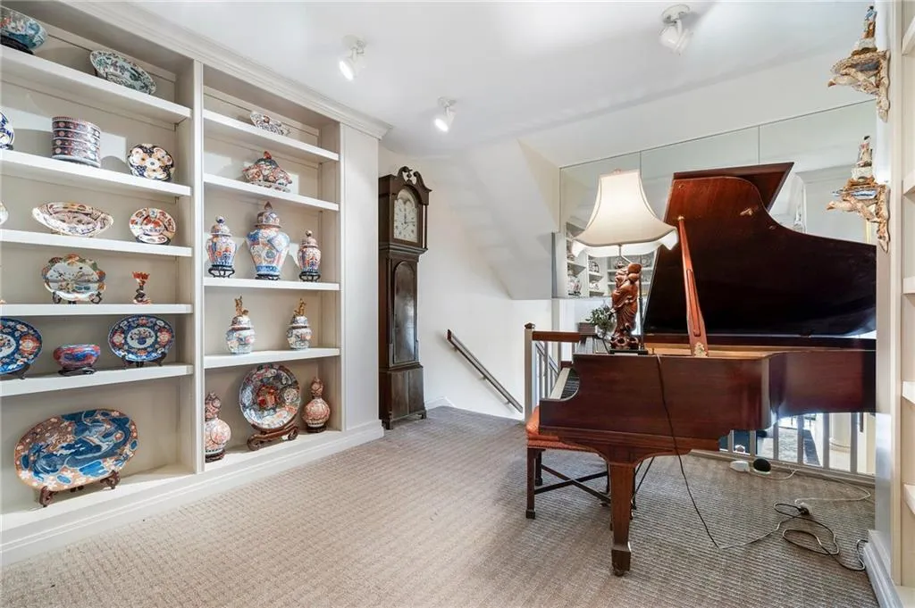 Sitting room with built in shelves, carpet, and an upstairs landing