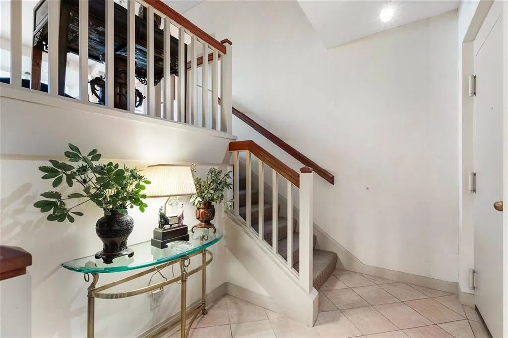 Stairway featuring tile patterned floors and baseboards