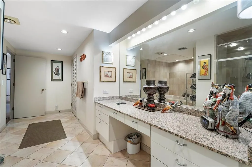 Bathroom with a stall shower, vanity, baseboards, and recessed lighting