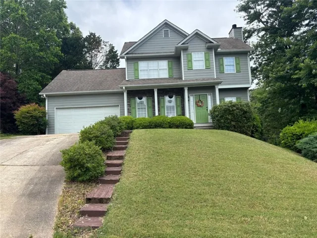 Two-story residence featuring light gray siding, white trim, and a prominent front porch