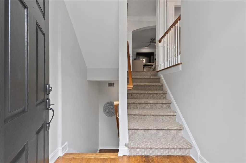 Stairs featuring wood foyer with hardwood finished floors