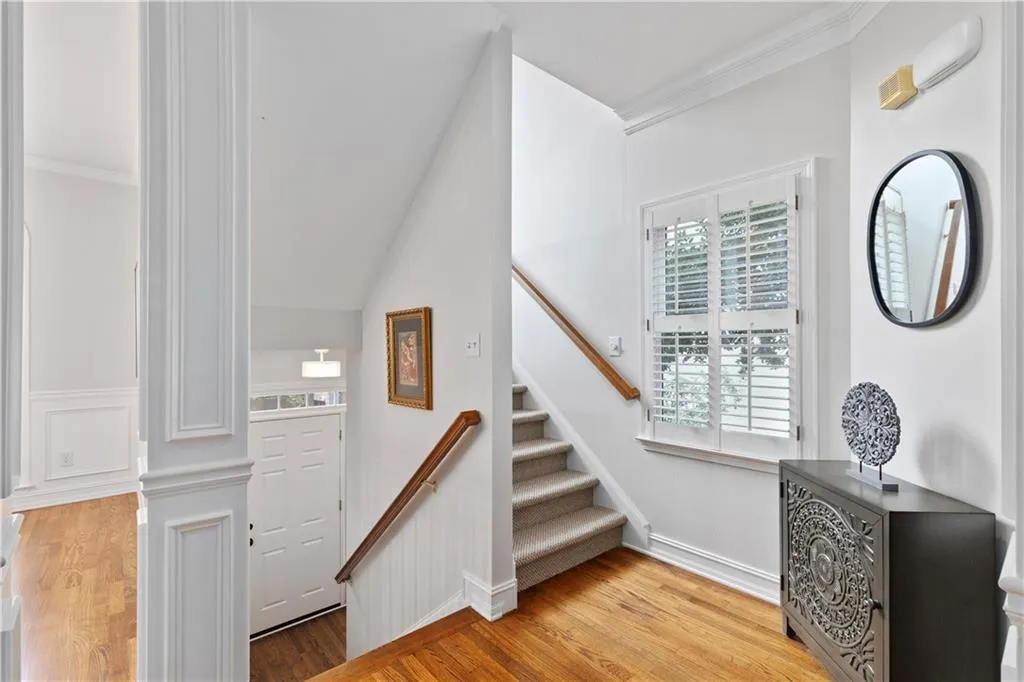 Staircase featuring wood Foyer Hardwood finished floors and crown molding