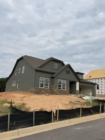 Two-story residence featuring shingle roofing, siding exterior, stone veneer accents, and a covered entry