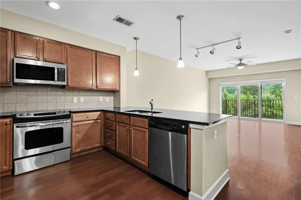 Modern kitchen featuring stainless steel appliances including a built-in microwave, electric range, and dishwasher