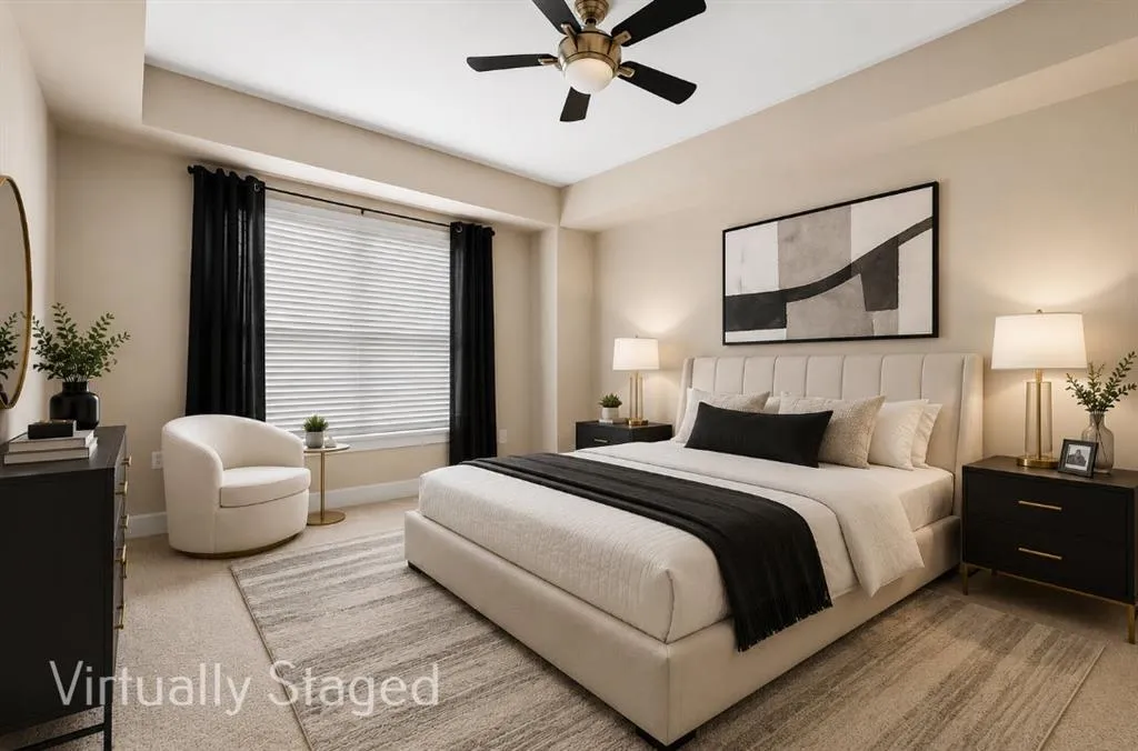 Carpeted bedroom featuring a window with blinds and dark drapery, a ceiling fan with integrated lighting, and neutral wall tones