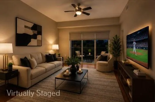 Spacious living area featuring wood-finish flooring, neutral paint, and access to a large balcony. Evening View