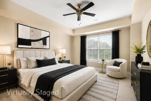 Large primary bedroom with neutral wall tones and neutral colored carpet, adjacent to custom closet system and bathroom.-Daylight View