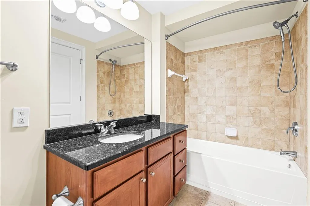 Large spa-like bathroom featuring a oversized vanity with a granite countertop and a combination tub/shower.