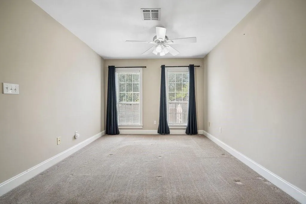 Spare room with light carpet and ceiling fan