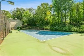 View of tennis court with a swimming pool