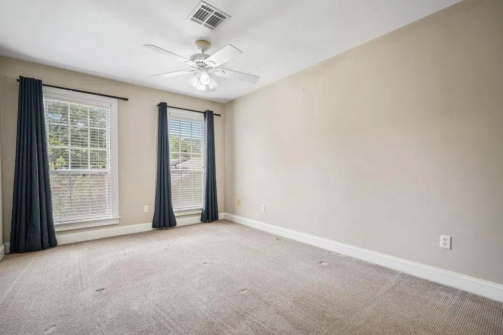 Spare room with ceiling fan and carpet floors